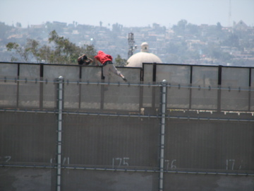 Immigrants clambering over the “triple fence” in San Diego