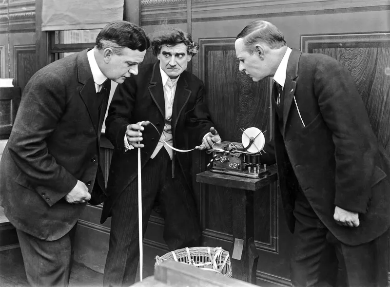 Brokers check the tape for daily prices in a scene from the film, 'The Wolf of Wall Street,' which opened just months before the crash in 1929, Hollywood, California, Underwood Archives. The Balance. Web.