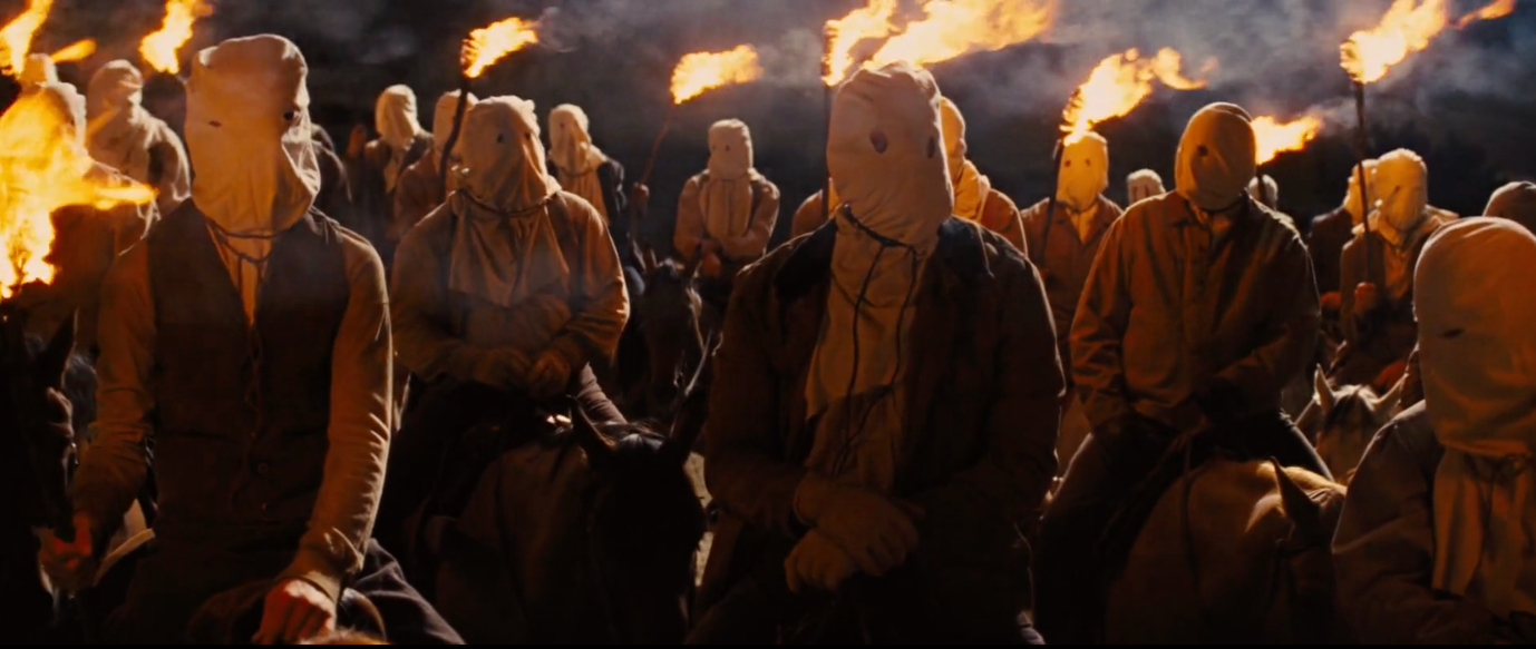 Scene with Ku Klux Klan using torches deep at night with "moonlighting" from above