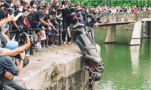 Black Lives Matter protesters push the statue of Edward Colston into Bristol Harbor.